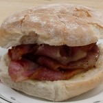 big stack of bacon in a floury bread roll