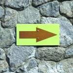 arrow against a stone wall, pointing right