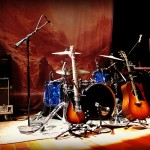 guitars, drums and mic stands set up for the band to begin