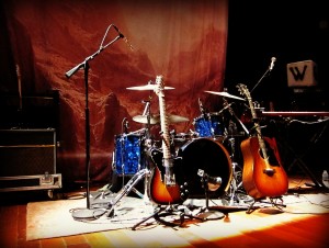 guitars, drums and mic stands set up for the band to begin